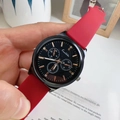 Close-up of black sports watch with rose gold hands and vibrant red silicone strap - Red