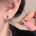 Gros plan détaillé d'une boucle d'oreille étoile en argent avec zircons et émail noir - Étoile Créole / Argent-Noir