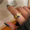Detail of gold irregular textured ring with blue gemstones worn on finger - Lava Texture With Double Gemstones Style (R1060)