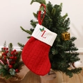 Knitted Christmas stocking in red with white cuff featuring embroidered letter L - Letter L