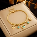 Goldenes Armband mit Evil-Eye-Anhänger und Herzanhängern auf einer Satin-Schmuckbox - Böser Blick Herzanhänger-Stil (B788) / Gold