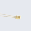 Elegante collana dorata con pendente a lettera E intarsiato di perle su sfondo grigio - Lettera E