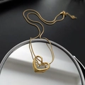 Golden double heart pendant necklace on snake chain displayed on a circular mirror base - Gold