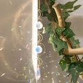 Close-up of golden crescent moon suncatcher with crystals creating rainbow reflections - B23 Style