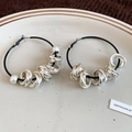 Macro view of hoop earrings with silver twisted rings and pearls on ceramic plate - S925 Silver Pin / Silver (Earrings)