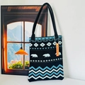 Detailed view of black knitted tote bag featuring blue white polar bear and wave patterns - Black Bear