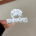 Dettaglio molletta in acetato da 6 cm con macchie blu stile terrazzo e impugnatura a cerchio - Blu Bianco