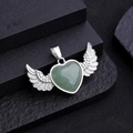 Silver heart wing pendant featuring a polished green natural stone on dark background - Green Aventurine