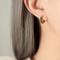 Gold hoop earrings with emerald green zircon pavé stones worn by a model in profile - Gold Green Zirconia