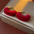 Detailed macro view of red flocked U-shaped earrings on a silk jewelry box - U-Shaped Flocked Ear Buckle Gold Plated Red