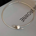 Detailed view of silver choker with oval crystal and arrow-shaped ends on display - Silver