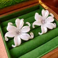 Elegante perlweiße Lilien-Ohrstecker mit Zirkonia-Mitte in einer grünen Vintage-Geschenkbox - Weiß