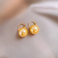 Detailed view of high-luster round pearl earrings on elegant champagne silk fabric - Gold Color Hoop With Pearl