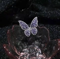 Macro detail of silver butterfly ring with purple stones and zircon on pink glass tray - Purple + Silver
