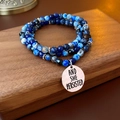 Gros plan de perles bleues avec pendentif en argent gravé AND SHE PERSISTED - Bleu (Bracelet Collier Double Usage)
