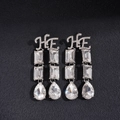 Dettaglio di orecchini a pendente argento con lettere HE e cristalli a forma di goccia - Lega/Strass/Perno in Argento 925 / Ago d'Argento - Orecchini d'Argento