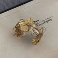 Nahaufnahme der Vintage Gold Armspange mit 3D Blumenmuster und feiner Texturierung - Altgold