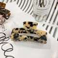 Large tortoiseshell acetate hair claw clip with leopard pattern on a stylish magazine - Creamy Leopard