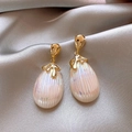 Gros plan sur des boucles d'oreilles perles en forme de goutte et métal doré sur satin - Style Fermoir Doré Goutte d'Eau Blanc Nacré Baroque