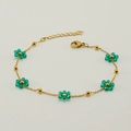 Golden chain bracelet with green flower beads and lobster clasp on white background - Bracelet / Green