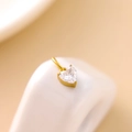 Macro shot of gold heart pendant with sparkling white cubic zirconia on white porcelain - Gold-White Zirconia