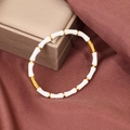 Detail view of gold-plated bamboo joint bracelet with white enamel inserts and buckle closure - White