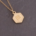 Detailopname van de gouden zeshoekige hanger met reliëfletter B aan een vintage ketting - Letter B (2#B)