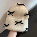 Cream knit rabbit fur beanie featuring six decorative black velvet bows for women - One Size(Stretchy) / Deep Beige