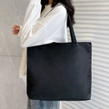 Minimalist large black canvas tote bag shown on shoulder for daily commute and shopping - Blank / Black