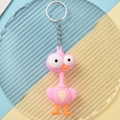Pink ostrich cartoon keychain with large eyes and orange accents on blue background - Ostrich