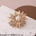 Détail d'une broche fleur dorée de 4,1 cm avec strass et perle centrale blanche - Style Fleur Strass Doré (B39)