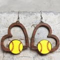 Detail von herzförmigen Holzohrringen mit Softball-Muster auf strukturiertem Stein - Softball