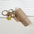 Mini beige tumbler keychain with a yellow star wearing a festive red Christmas hat - Christmas Beige