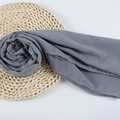 Dark grey chiffon hijab scarf with delicate curled edges on a woven straw mat backdrop - 100