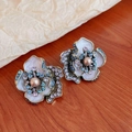 Macro detail of vintage court style flower earrings with blue rhinestones and center pearls - Silver Earring Post Earrings / Purple