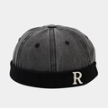 Detail der Retro-Dockermütze mit gealterter Denim-Krone und silbernem Metall-R-Logo - Schwarz