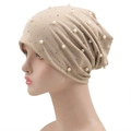 Detalle de gorro beige con perlas blancas artificiales y pedrería brillante de moda - Beige