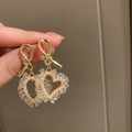 Detail of heart-shaped gold earrings with faux pearl and crystal stones held by hand - Golden Pearl Heart (7# Silver Needle)