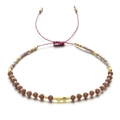 Close-up of Bohemian handmade woven bracelet with purple crystals and adjustable cord - Coffee