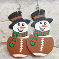 Close-up of leather earrings featuring creative snowman and American football designs - American Football Snowman