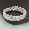 Macro-detail van de drielaagse parelarmband met vierkante strass en zilveren accenten - 3 Rijen Zilver