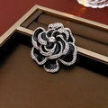 Detail einer schwarzen Emaille-Kameliembrosche mit glitzernden Strassrändern und Mitte - Brosche - Schwarz