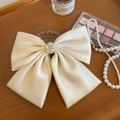 Dettaglio fermaglio per capelli in raso beige con fiocco grande e fiore di perle eleganti - Grande / Bianco Sporco