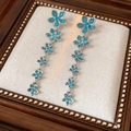 Dettaglio di orecchini a goccia in argento con cinque fiori di zircone blu a cascata - Nappa a Fiore Lunga / Perno in argento-Blu