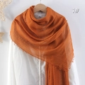 Orange linen cotton scarf with frayed tassel edges on a hanger over a white shirt - Orange
