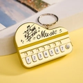 Gold metal piano keychain with music score engraving and seven white numbered keys - Bag Packaging / Gold