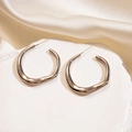 Detailed view of large irregular gold hoop earrings with a liquid metal texture - Silver