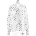Detail van elegante witte polkadot blouse met stijlvolle strikhals en lange mouwen - S / Wit