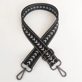 Close-up of adjustable nylon bag strap with black geometric embroidery and metal hooks - Black Silver Thread + Gunmetal Buckle