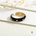 Detail of 18K gold plated open ring featuring black enamel and gold star patterns - Black